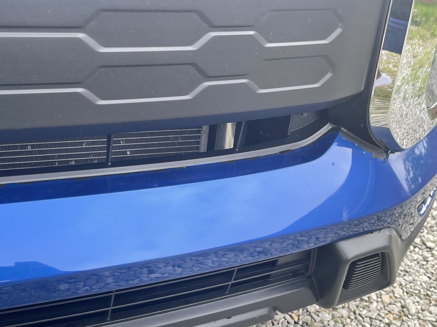 Repaired front bumper assembly on a blue SUV after collision body work